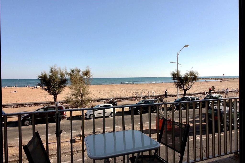 - une vue sur la plage dotée d'une table et de chaises dans l'établissement Appartement confortable en front de mer pour 5 personnes, à Valras-Plage