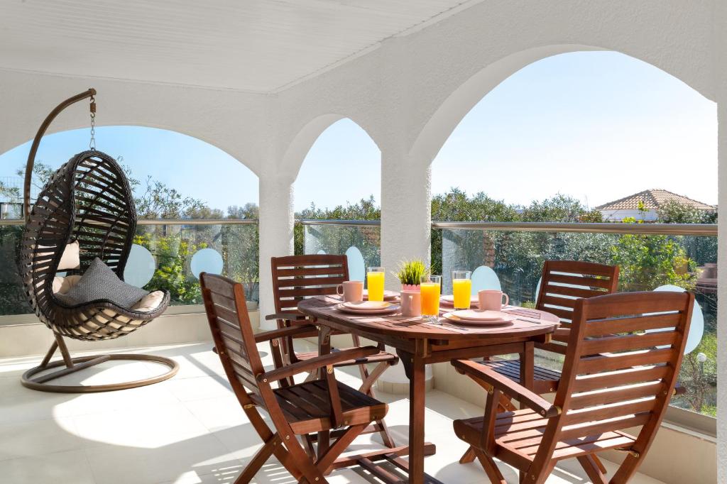 a dining room with a table and chairs and a balcony at House of Paradise in front of the golf court-sea in Rhodes Town
