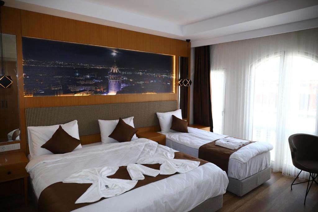 a hotel room with two beds and a picture on the wall at Ruby Royal in Istanbul