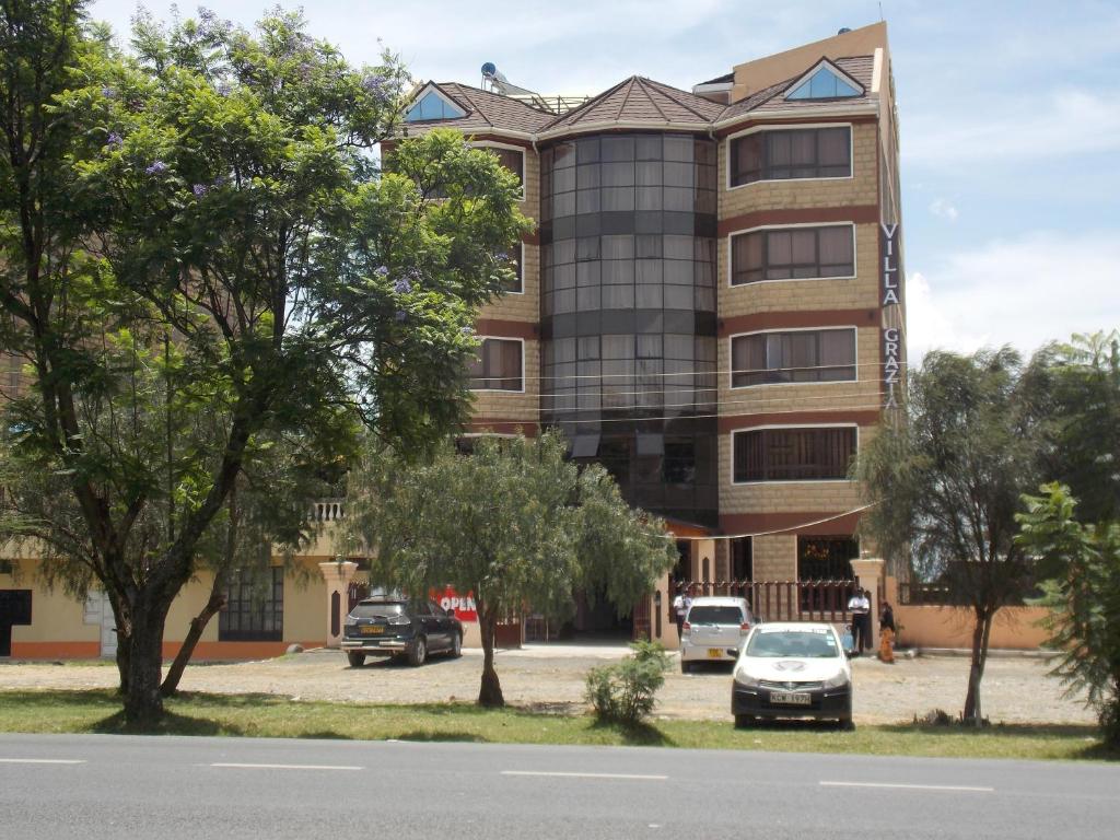 ein großes Gebäude mit davor geparkt in der Unterkunft Villa Grazia Luxury Hotel in Naivasha