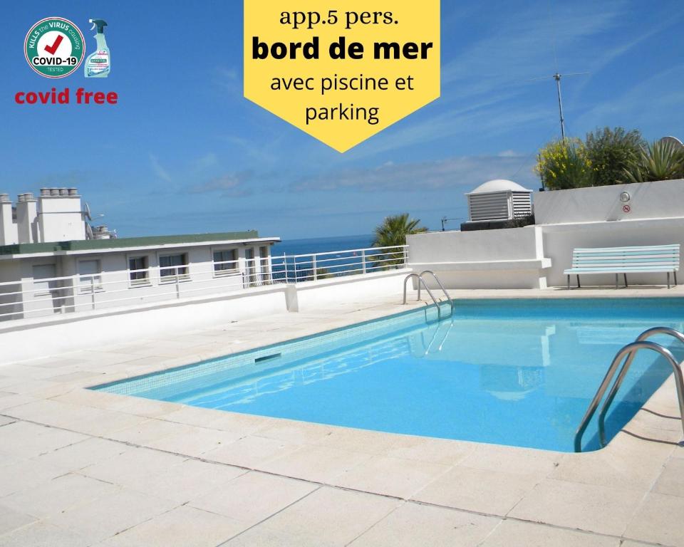 a swimming pool with the ocean in the background at app Le Rocazur avec piscine et parking en bord de mer à 500M du centre ville in Menton