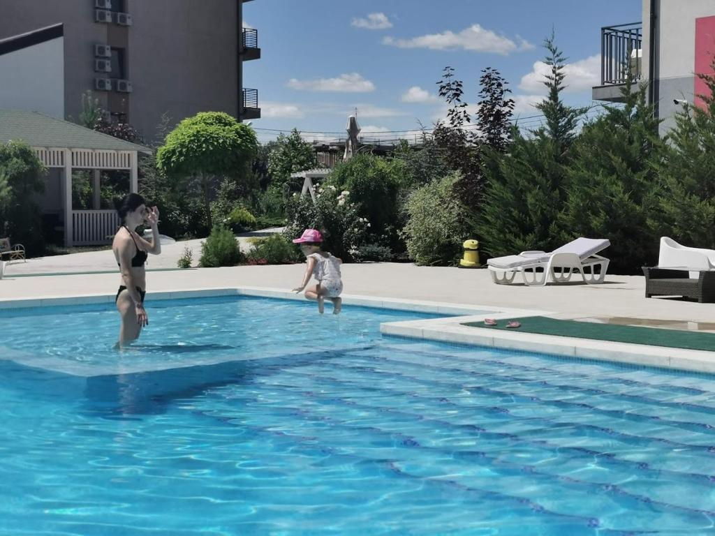 a man and a child standing in a swimming pool at Sangria Luxury Family in Mamaia Nord