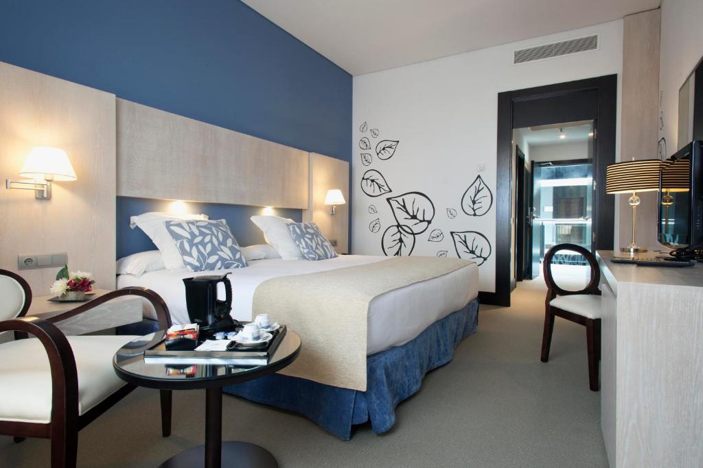 Una habitación de hotel con una cama, una mesa y sillas. en Hotel Nuevo Boston, en Madrid