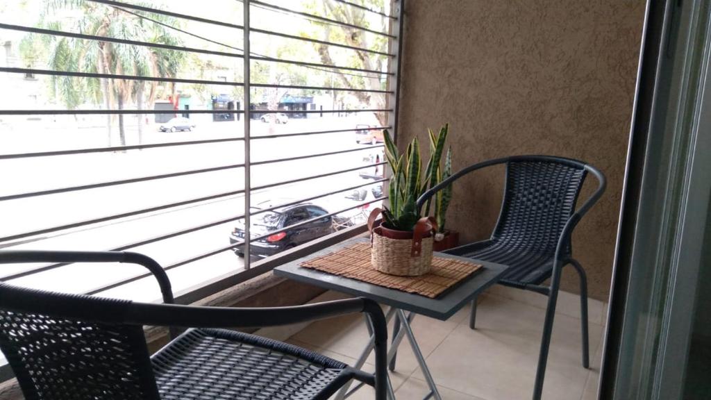 einen Balkon mit 2 Stühlen und einem Tisch mit einer Pflanze in der Unterkunft Departamento Zona Norte in Rosario