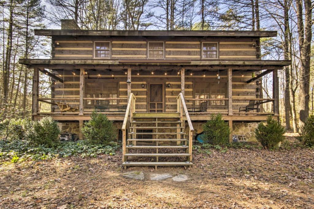 a large wooden house in the woods with stairs at Riversong Luxe Cabin with Fire Pit on North River in Slanesville