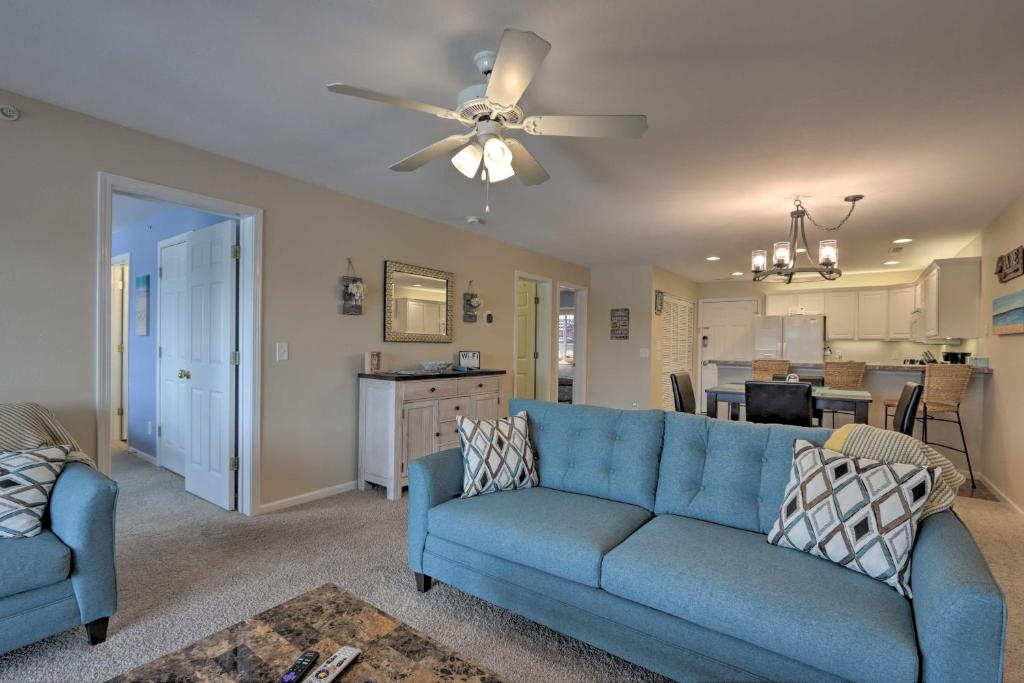 a living room with a blue couch and a kitchen at The Lake Escape with Balcony and Pool Access! in Camdenton