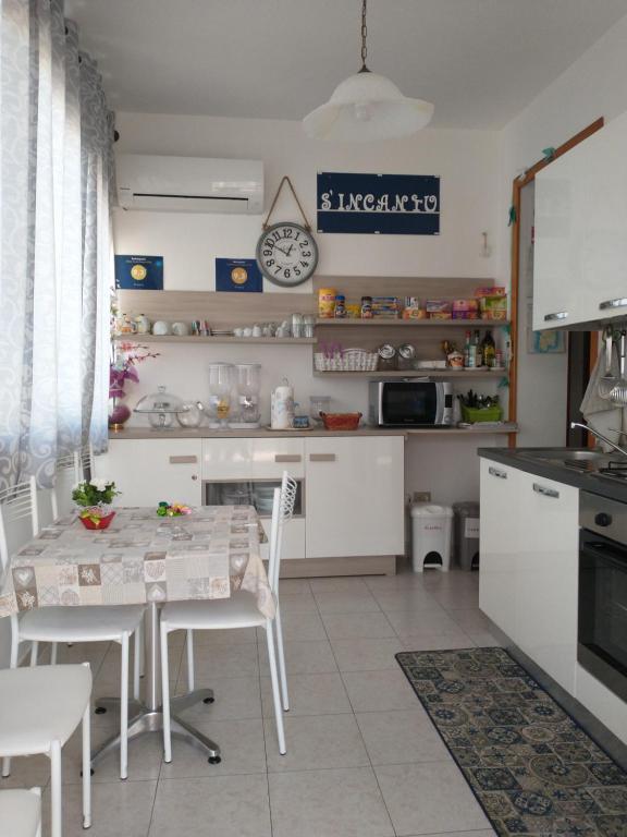 a kitchen with a table, chairs and a refrigerator at S'incantu in Olbia
