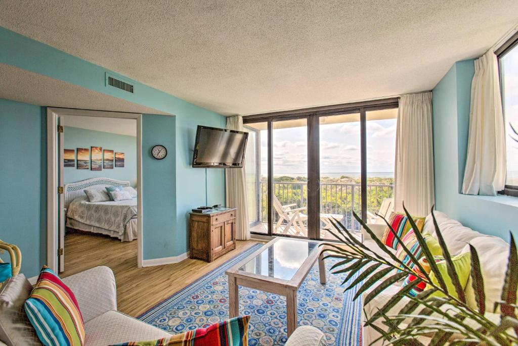 ein Wohnzimmer mit einem Zimmer mit einem Bett und einem TV in der Unterkunft Sands Villa Resort Oceanfront Condo with Pools! in Atlantic Beach