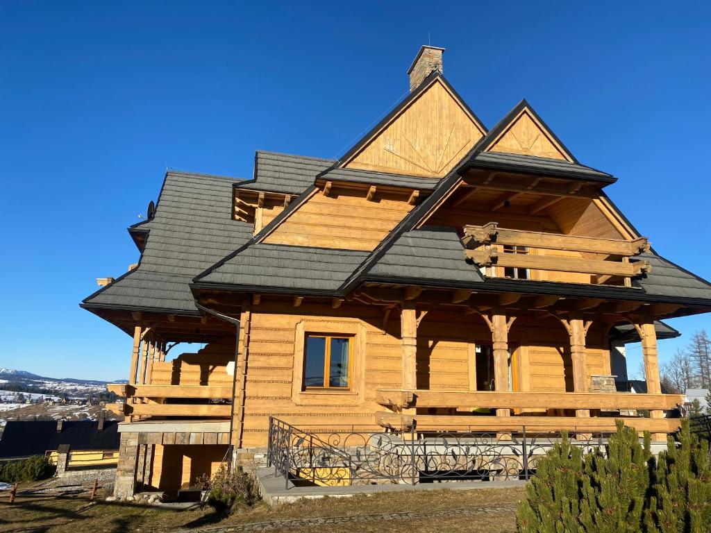 a large wooden house with a black roof at udanypobyt Dom Hillside in Gliczarów