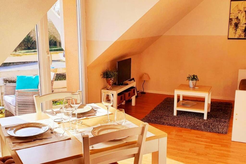 una sala da pranzo con tavolo e una camera con mansarda di Bulle d'évasion Aux portes de Honfleur - Piscine couverte a Boulleville