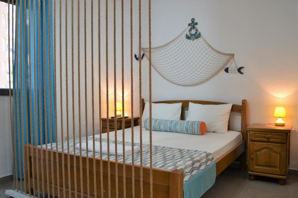 ein Schlafzimmer mit einem Bett mit einem hängenden Bettrahmen in der Unterkunft Yeshill Apart & Studio in Budva