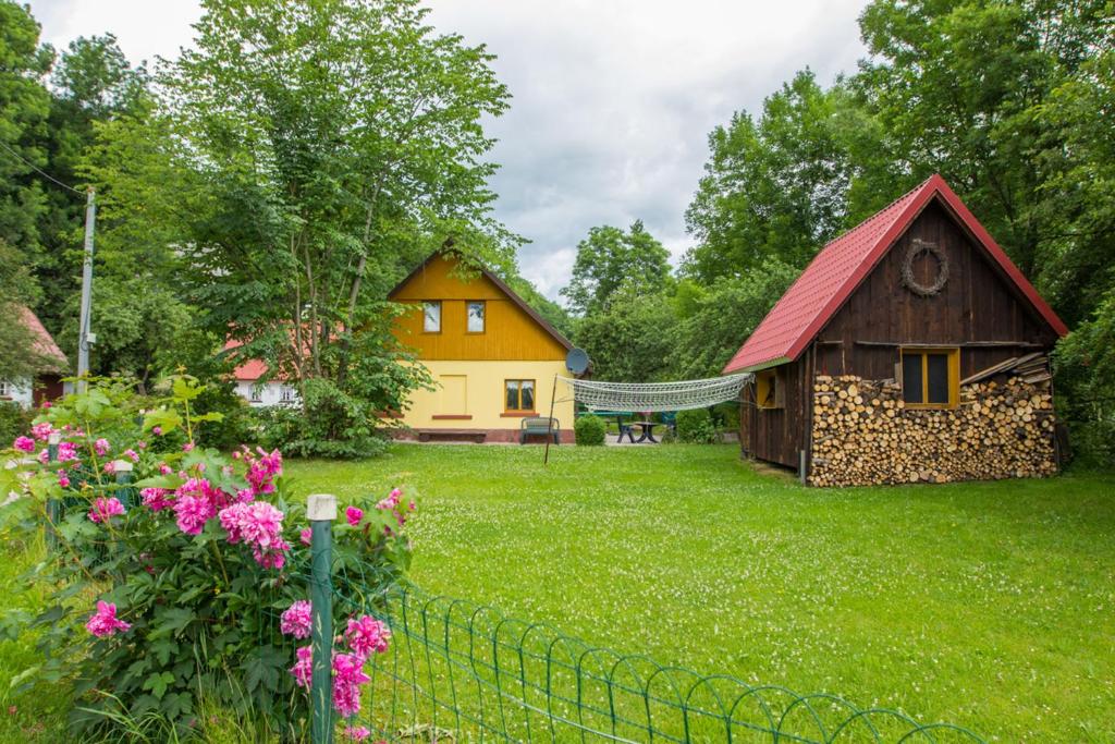 un patio con una casa y una valla y flores en Family House Dolni Lanov en Dolní Lánov
