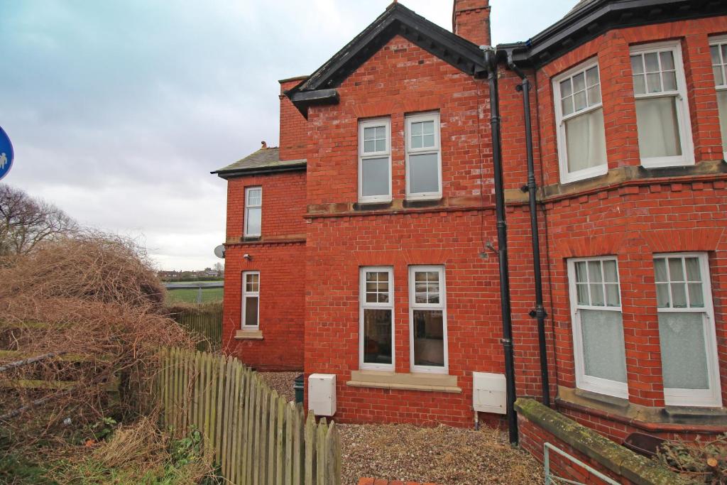 una casa de ladrillo rojo con una valla delante de ella en Large period Chester home right on the canal. en Chester