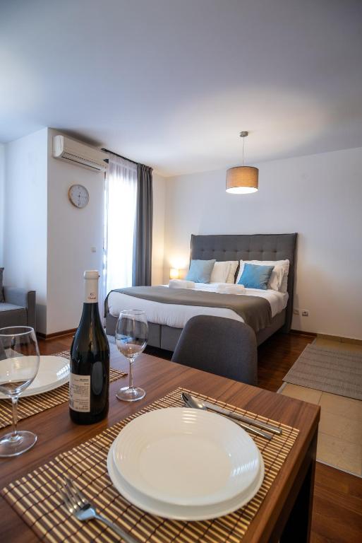 a room with a table with a bottle of wine and a bed at Apartman Paradiso 211 in Vrnjačka Banja