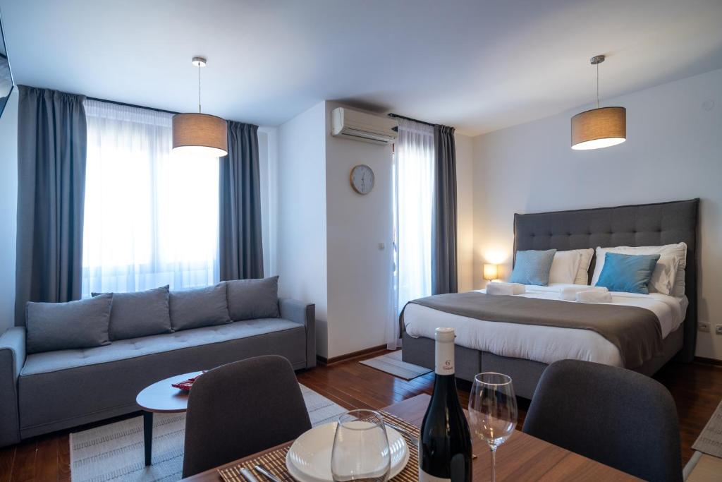 een slaapkamer met een bed, een bank en een tafel bij Apartman Paradiso 211 in Vrnjačka Banja