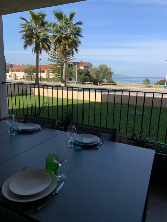 una mesa con platos y vistas al océano en Appartement CUMARU vue mer, en Saint-Florent