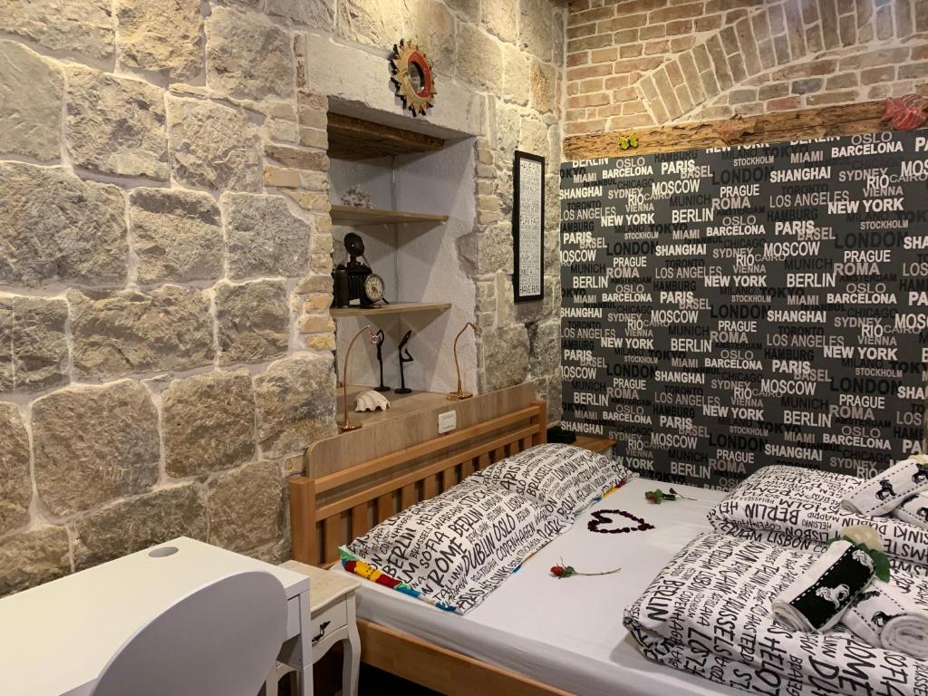 Pokój z 2 łóżkami i kamienną ścianą w obiekcie Luxury Art Room w Splicie