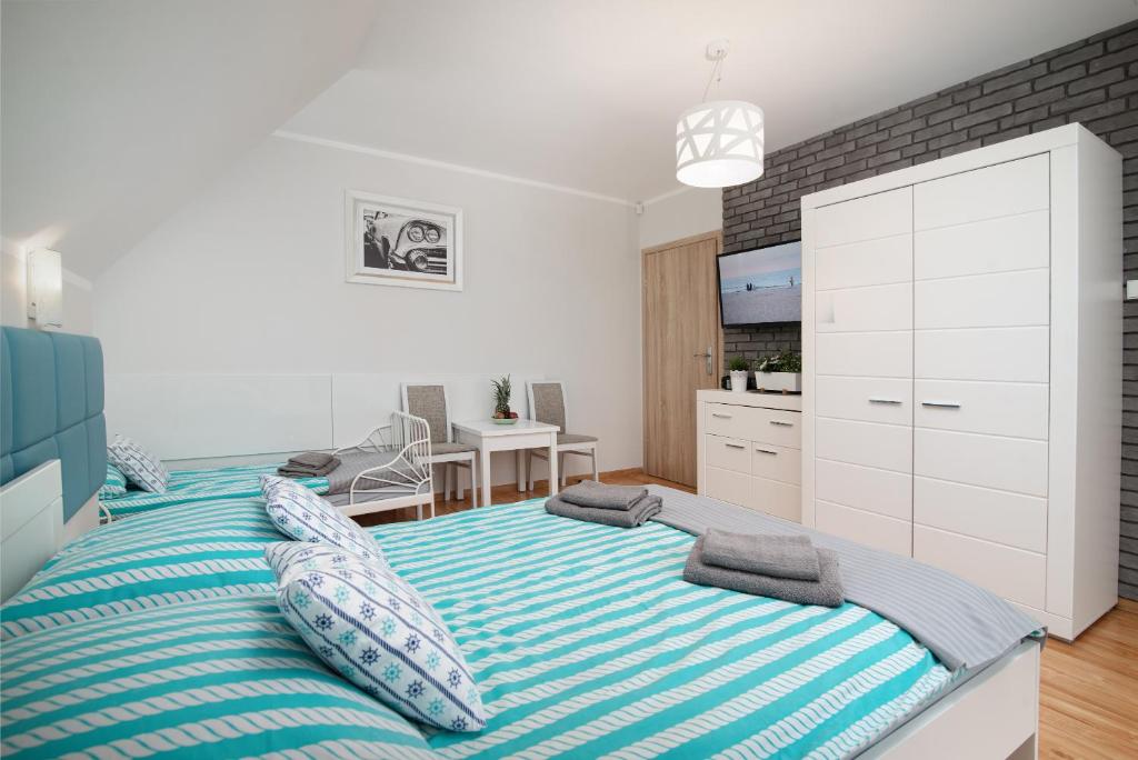Un dormitorio con una cama grande con almohadas. en Pokoje Jelonek en Władysławowo