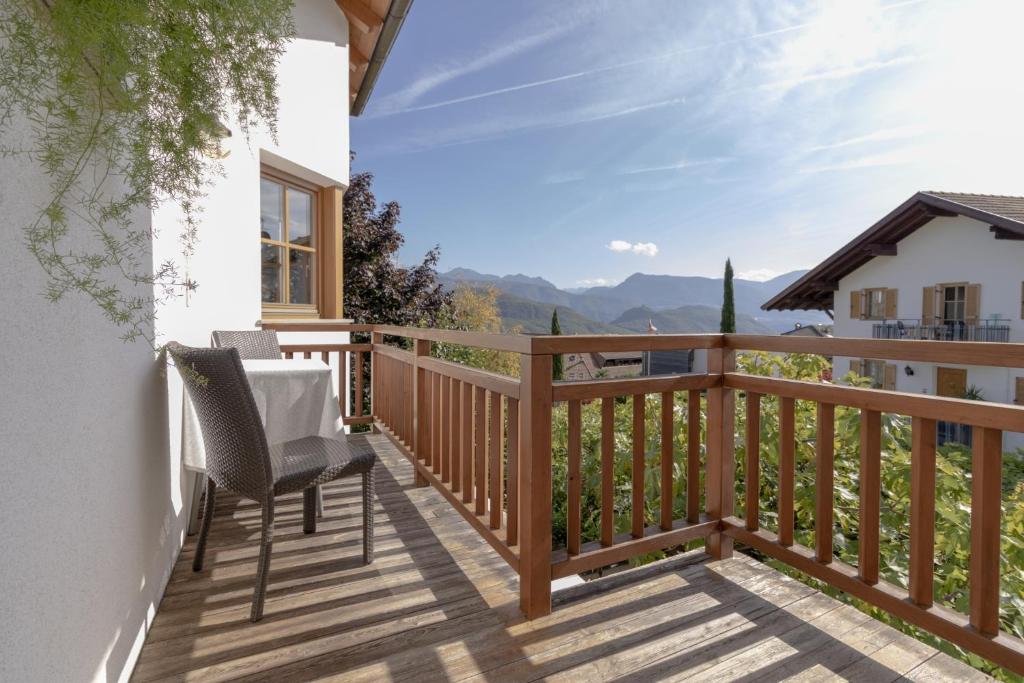 une terrasse en bois avec une table et des chaises. dans l'établissement Stompferhof Familienapartment, à Caldaro