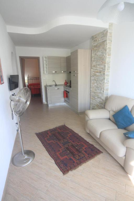 a living room with a white couch and a kitchen at Vernazza Vacation 2 in Vernazza