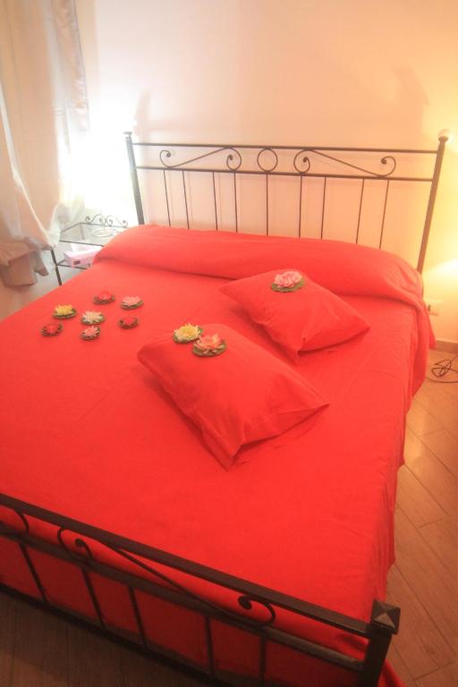 a red bed with red pillows and cookies on it at Vernazza Vacation 2 in Vernazza