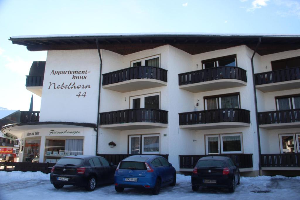 un edificio con tres coches estacionados frente a él en Nebelhorn-Appartments 124 - 206 - 210 - 213 - 216 - 217, en Oberstdorf