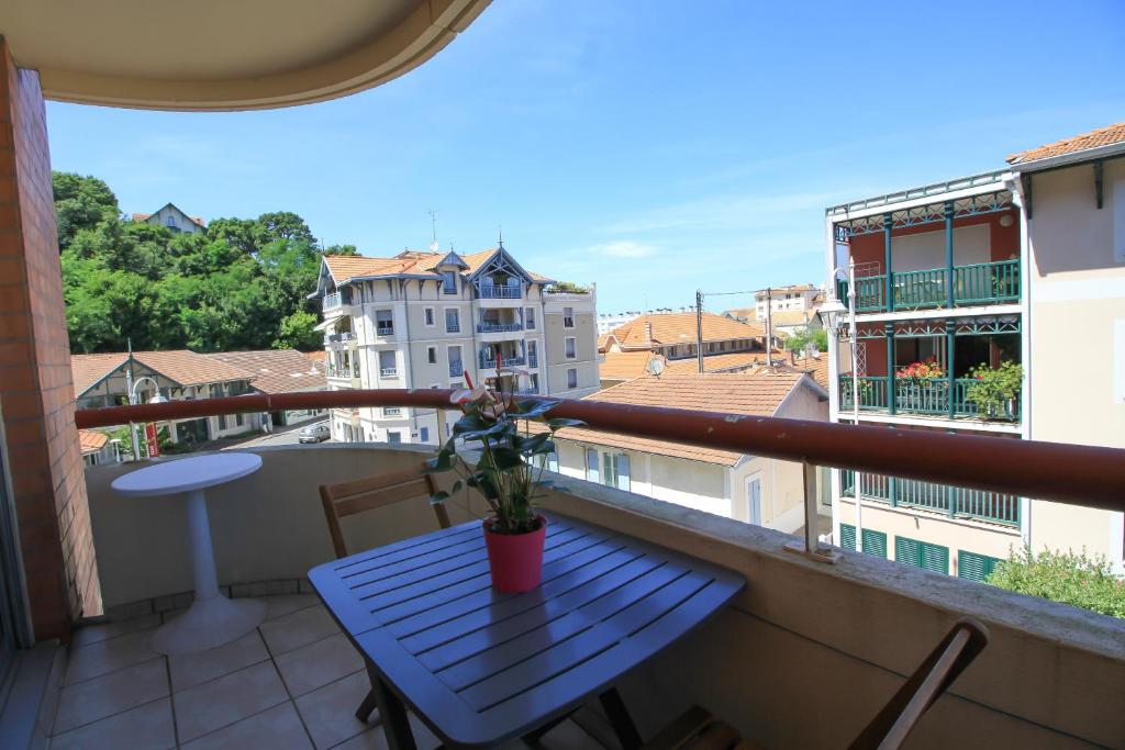 une table bleue sur un balcon avec vue sur la ville dans l'établissement Mauresque, à Arcachon