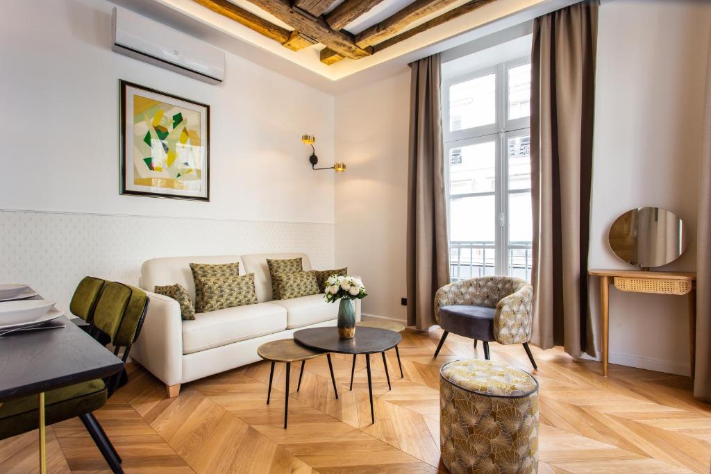 een woonkamer met een bank en een tafel bij CMG Résidence République - Rue Béranger in Parijs