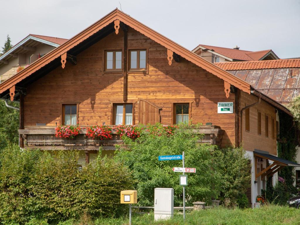 a wooden house with flowers on a balcony at Gästehaus Madsack - Chiemgau Karte in Inzell