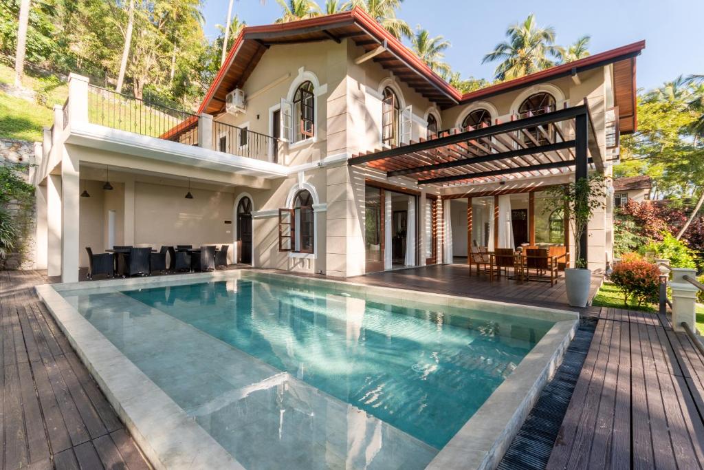 a swimming pool in front of a house at Villa Merak, Digana in Digana