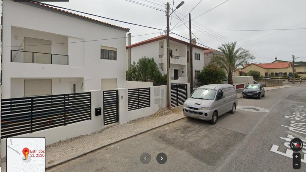 un coche aparcado en un aparcamiento al lado de un edificio en Casa do coral, en Peniche