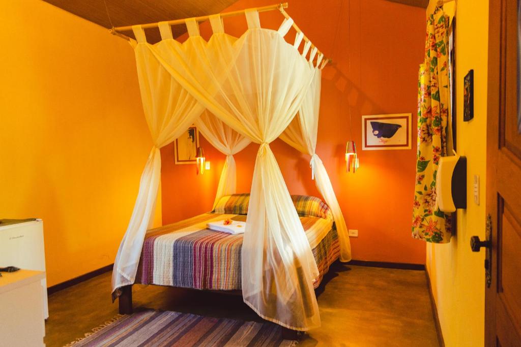 a bedroom with a bed with mosquito netting at Vila Clara do Capão in Vale do Capao