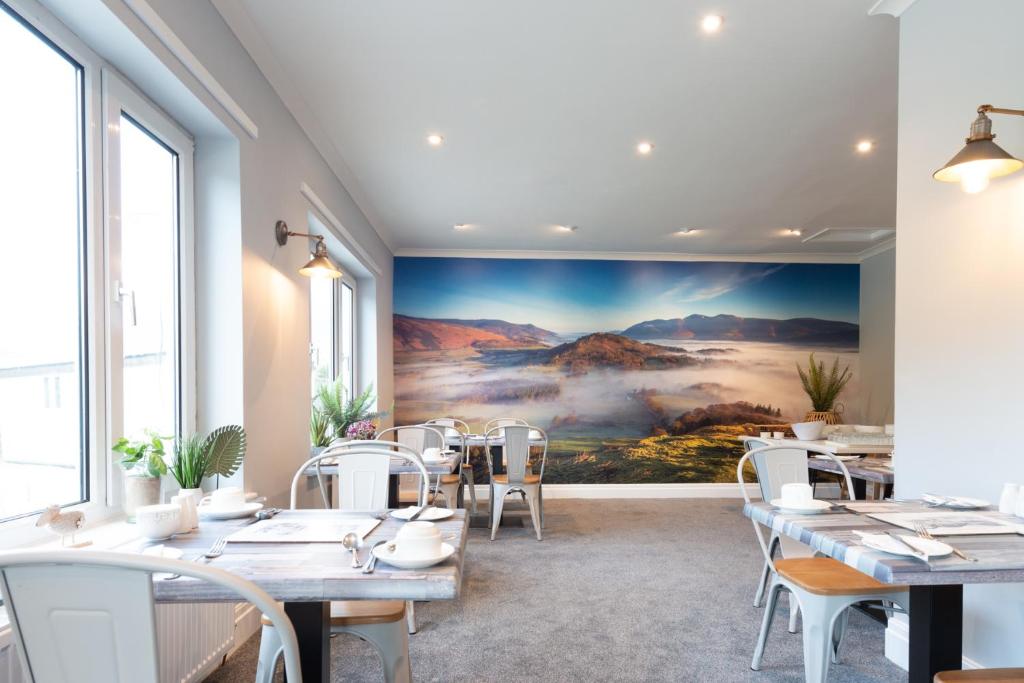 a restaurant with a large painting on the wall at Rickerby Grange in Keswick