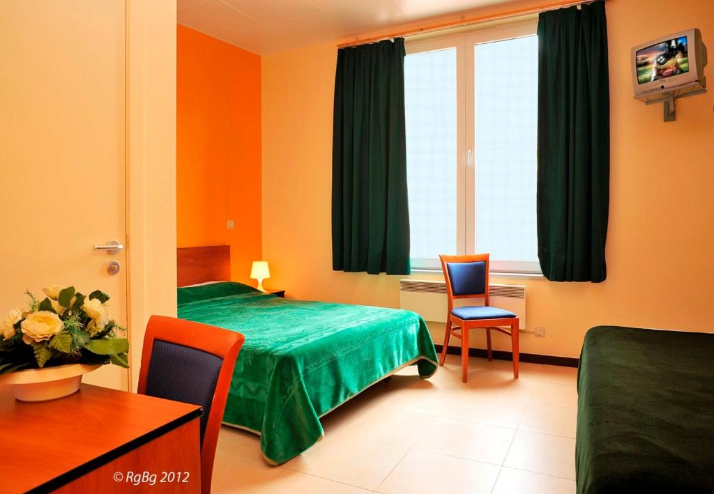 una camera d'albergo con letto, tavolo e sedie di Hotel The Moon a Bruxelles