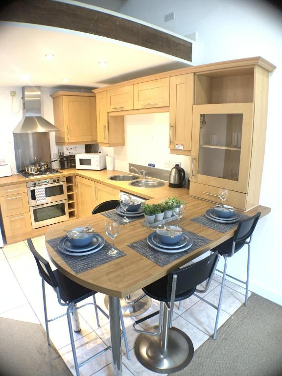 a kitchen with a wooden table with chairs around it at Grand Central Apartments, The Mill in Derby