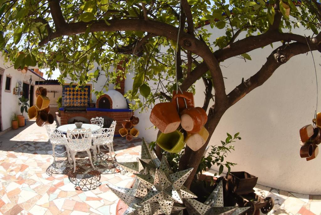 een tafel en stoelen onder een boom op een binnenplaats bij HOTEL CASA LIMON in Santa Rosa de Jáuregui