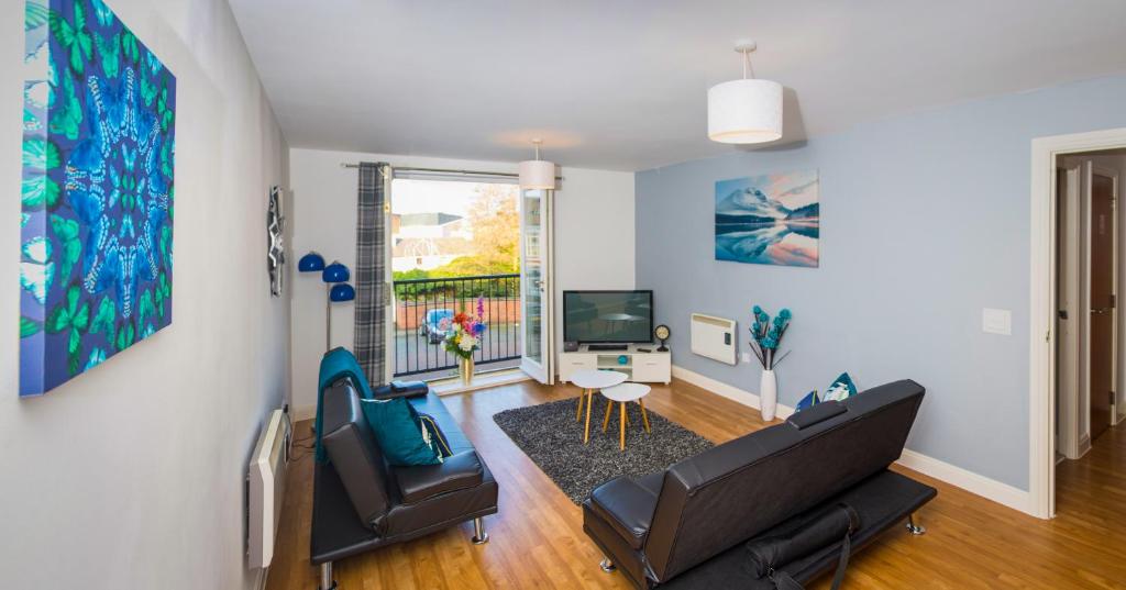 a living room with a couch and chairs and a tv at Grand Central Friar Gate Deluxe Apartments in Derby