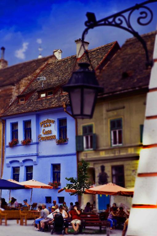 a group of people sitting in front of a building at Casa Saseasca in Sighişoara