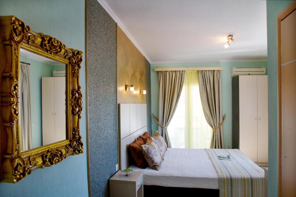 ネオス・マルマラスにあるKaplanis Houseのベッドルーム1室(鏡付きのベッド1台、窓付)