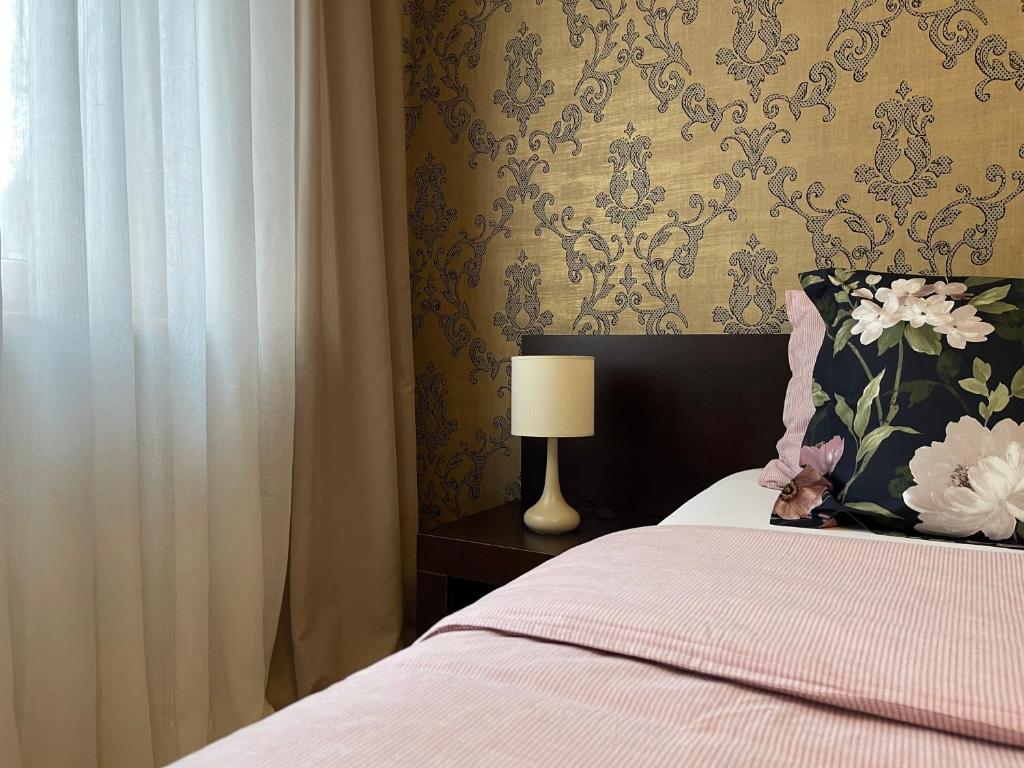 Dormitorio con cama con almohada y lámpara en Apartament PolnaHouse, en Sieradz