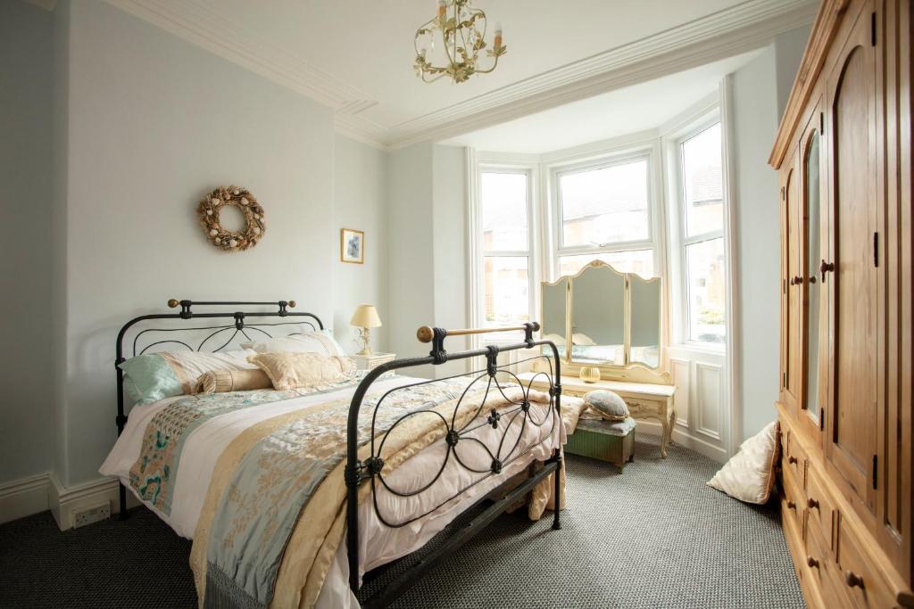 a bedroom with a bed and a chandelier at Seascape in Whitley Bay