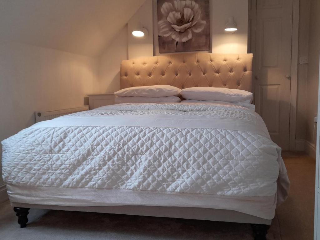 1 dormitorio con cama blanca y edredón blanco en Annaswood B&B, en Cahir