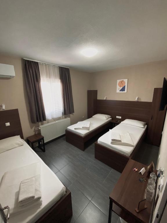 ein Hotelzimmer mit 2 Betten und einem Tisch in der Unterkunft Hotel Djerdan in Kraljevo