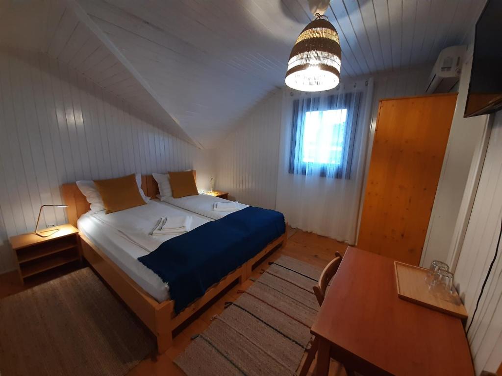 - une chambre avec un lit, une table et une fenêtre dans l'établissement Pensiunea Valurile Dunarii, à Sfântu Gheorghe