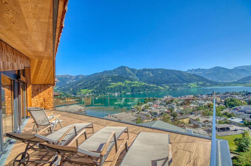 a balcony with chairs and a view of a lake at Eagles Nest - by Alpen Apartments in Zell am See