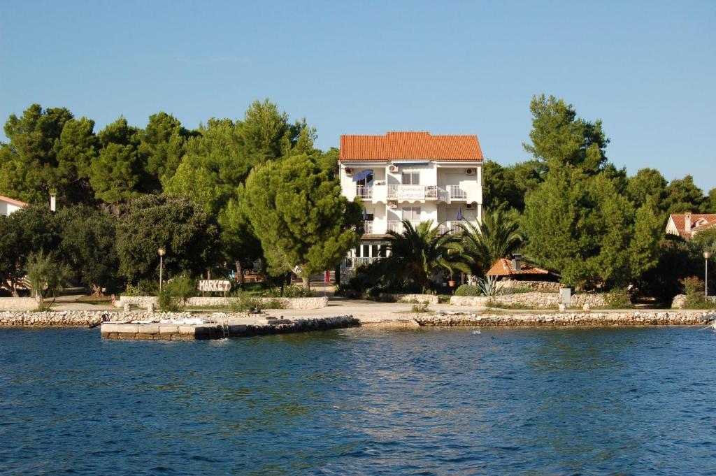 a house on the shore of a body of water at Gorgonia Apartments in Verunić