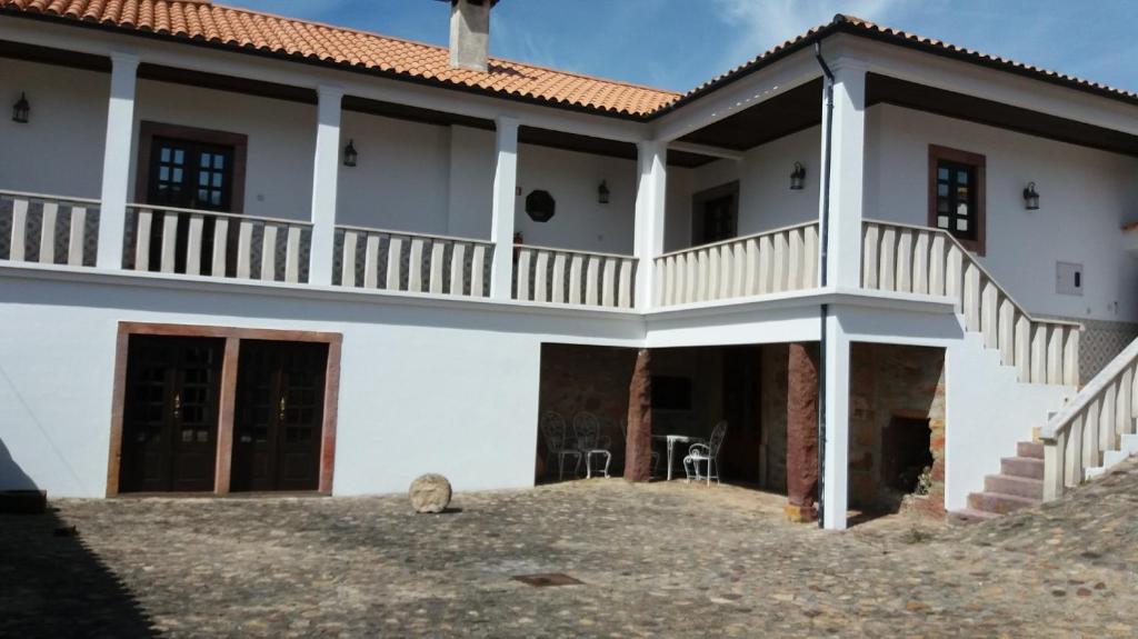 Großes weißes Haus mit Balkon in der Unterkunft Pátio das Mós in Vila Nova de Poiares