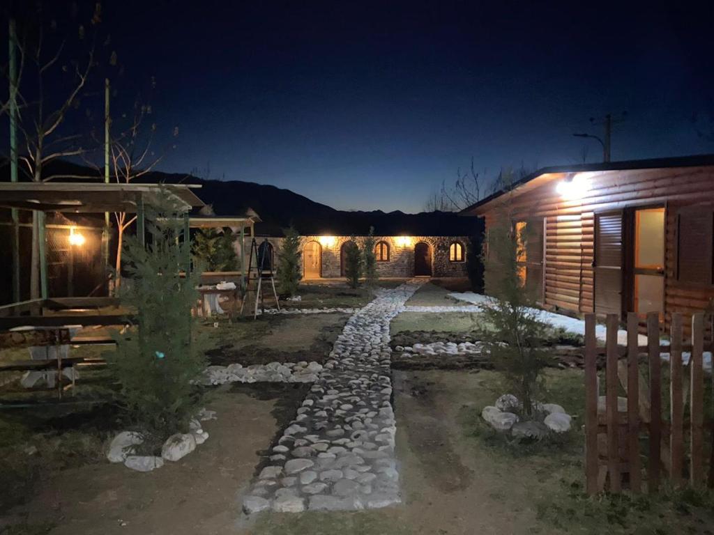 a stone path leading to a house at night at Windmill Shkodra Gesthouse Camping & Grill in Shkodër