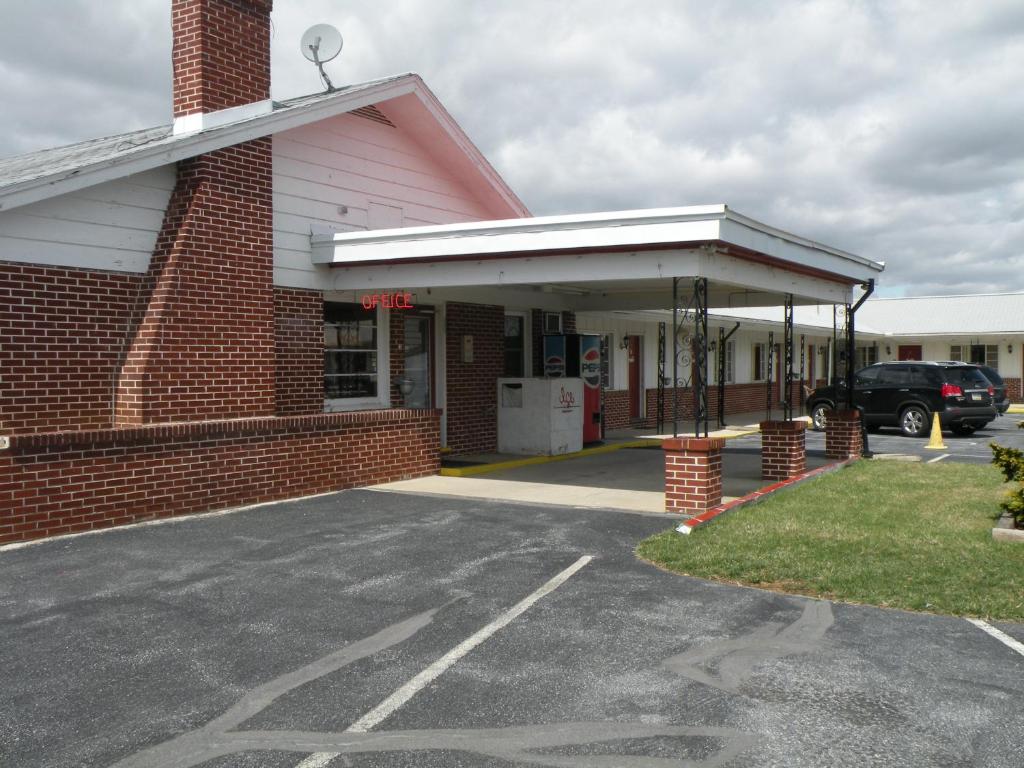 a parking lot in front of a brick building at Scottish Inns Fayetteville in Fayetteville