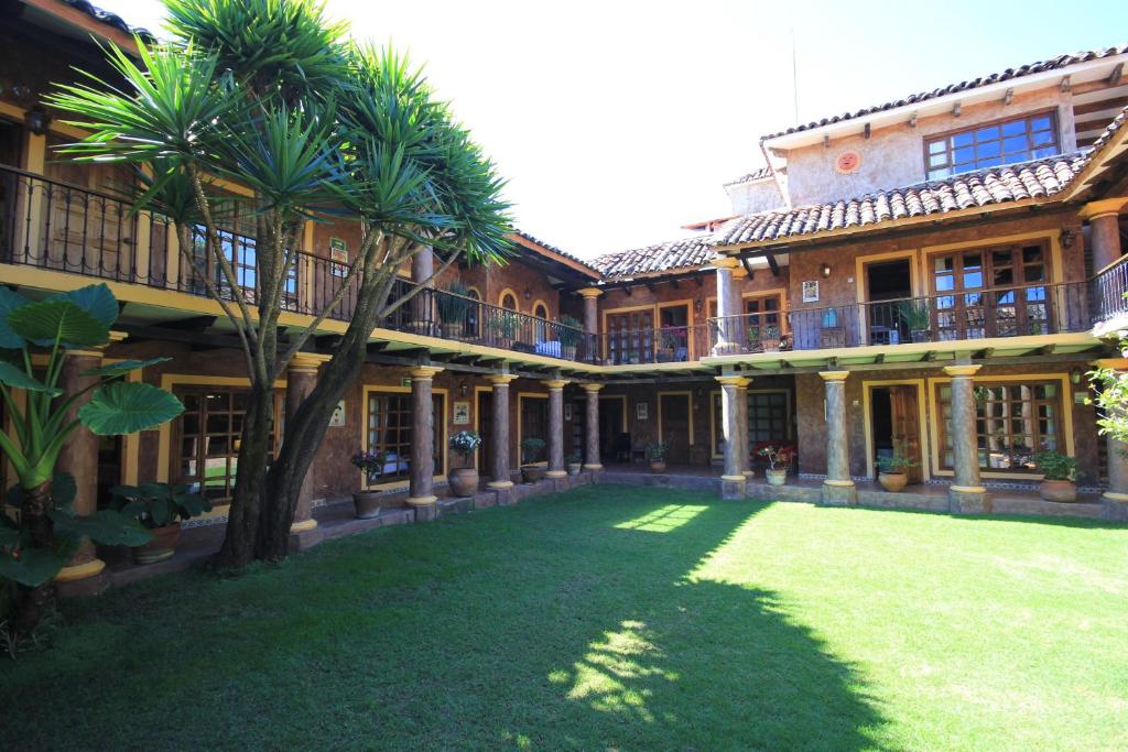 ein großes Gebäude mit Palmen im Hof in der Unterkunft Hotel Casa Mexicana in San Cristóbal de las Casas